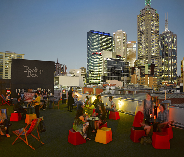 People enjoying themselves on Melbourne CBD rooftop bar at dusk